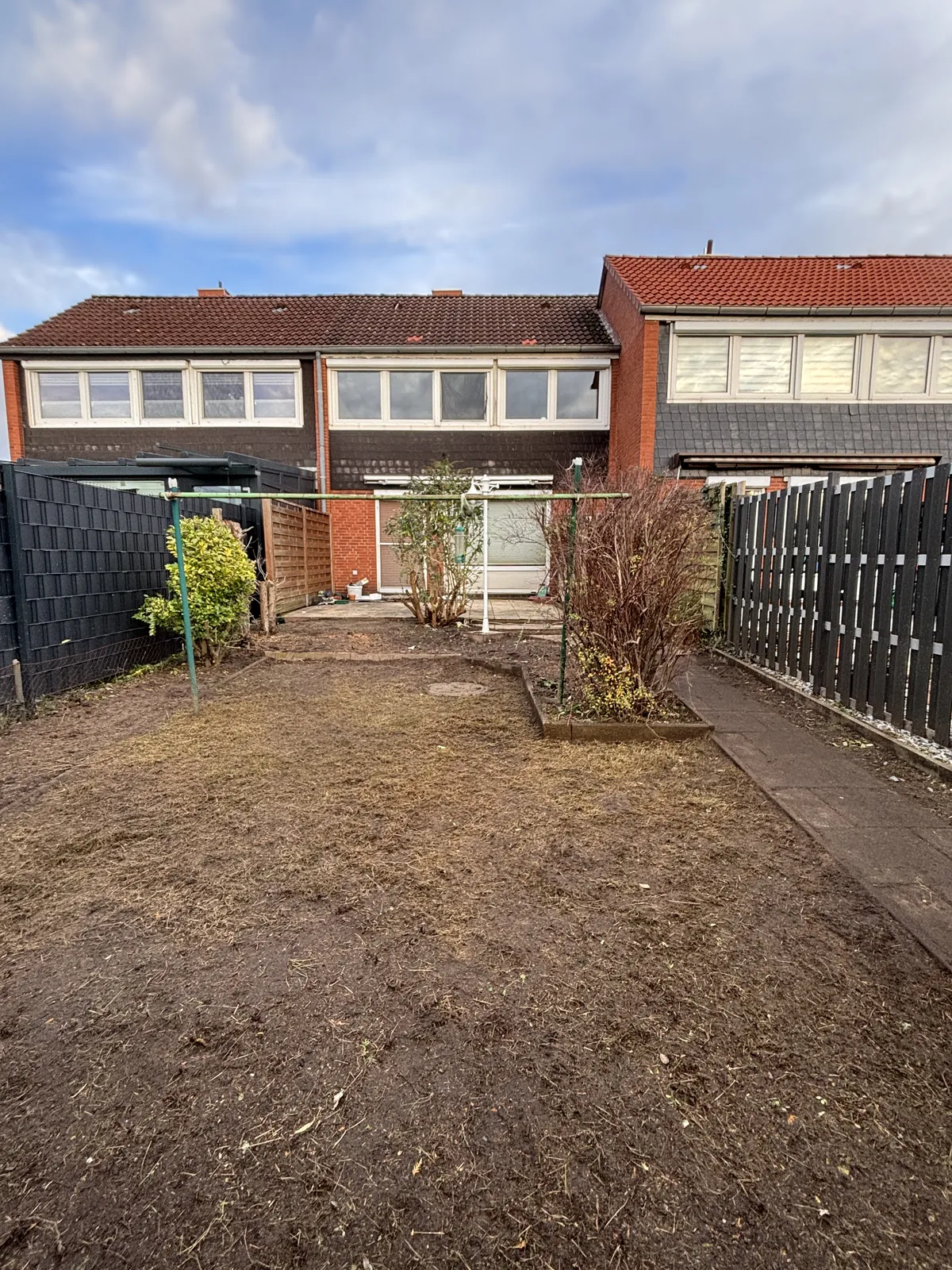Gartenfläche mit bearbeitetem Boden, Blick auf die Häuser